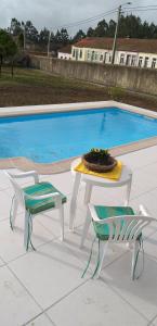 a table and two chairs next to a swimming pool at Casa da Carlota in São Vicente de Pereira Jusã