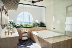 a bathroom with a large tub and a window at Cap Juluca, A Belmond Hotel, Anguilla in West End Village