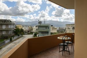 uma varanda com uma mesa e cadeiras com vista para uma cidade em Simantiris Apartment em Asímion