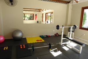 una habitación con gimnasio con cinta de correr y pesas en Pousada Praia de Itamambuca en Ubatuba