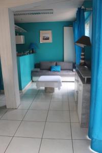 ein blaues Wohnzimmer mit einem Sofa und einem Tisch in der Unterkunft Appartement Annie LLENSE in Argelès-sur-Mer