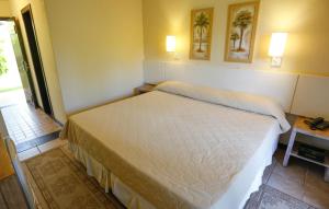 a bedroom with a large white bed in a room at Palmas Hotel & Spa in Governador Celso Ramos