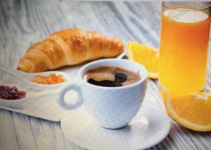 una tazza di caffè e croissant e un bicchiere di succo d'arancia di Na tazzulel e cafe a Napoli