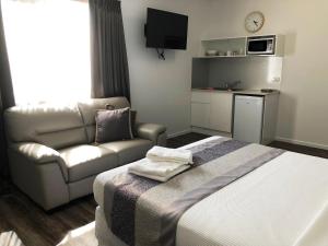 a hotel room with a bed and a couch at Escape On Lake in Cairns