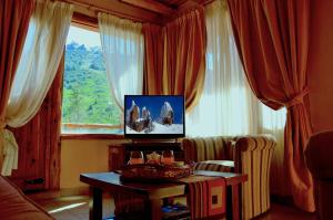 sala de estar con TV, mesa y ventana en Posadas Aurelio en San Carlos de Bariloche