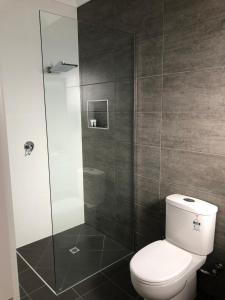 a bathroom with a toilet and a glass shower at Escape On Lake in Cairns