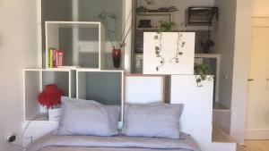 - une étagère blanche avec un canapé dans l'établissement Nid Douillet pour 2, à Sfax