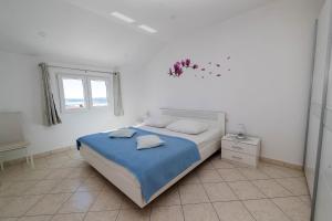 a white bedroom with a bed and a window at Apartment Crikvenica 1 in Crikvenica