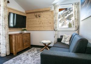 a living room with a couch and a tv at Appartement Alpenliebe in Rauris