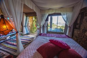 a bedroom with a bed with a large window at Villa Buena Vista in Praia do Rosa