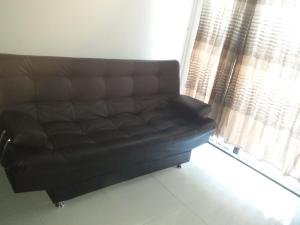 卡塔赫纳Cómoda y bonita habitación Independiente的窗户房间里一张黑色皮沙发 更多1张照片
