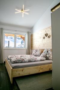 a bedroom with a bed with a wooden headboard at Appartement Alpenliebe in Rauris
