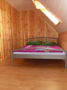 a bed in a room with a wooden wall at Domki Nad Jeziorem Karłowice in Karłowice