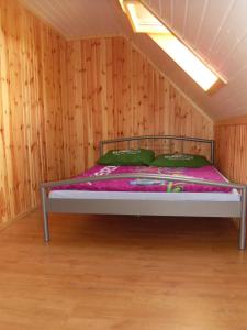 een bed in een kamer met een houten muur bij Domki Nad Jeziorem Karłowice in Karłowice