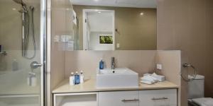 
a bathroom with a sink, toilet and shower at O'Reilly's Rainforest Retreat in Canungra
