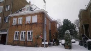 una casa de ladrillo con nieve en el suelo en B&B Pickery en Brujas