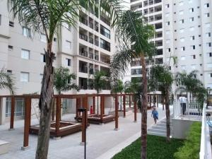 a courtyard with palm trees in front of a building at Apto em santos 900 m praia in Santos