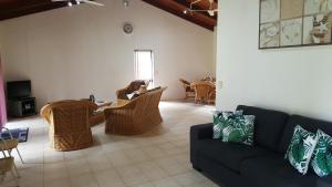 un soggiorno con divano, tavolo e sedie di Te Vaiora Villa a Rarotonga