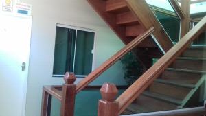 uma escada de madeira numa casa com uma janela em Pousada Belezinha em Arraial do Cabo