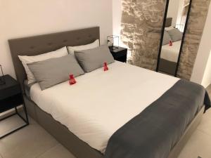 Una cama grande con dos arcos rojos encima. en Levante Luxury Room, en Giovinazzo