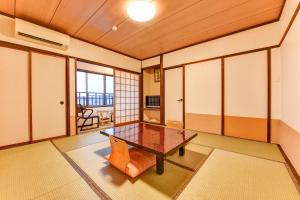 Cette chambre comprend une table et une chaise. dans l'établissement Hidatakayama Futarishizuka Hakuun, à Takayama