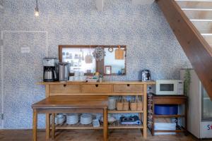 a kitchen with a table with a mirror and a microwave at Beach Side Inn Shirahama in Shimoda