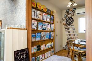 a room with a book shelf filled with books at Beach Side Inn Shirahama in Shimoda