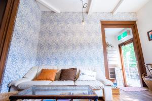 a living room with a white couch against a blue wall at Beach Side Inn Shirahama in Shimoda