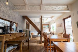 cocina y comedor con mesas y sillas de madera en Beach Side Inn Shirahama, en Shimoda