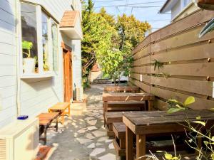 a patio with wooden tables and benches next to a building at Beach Side Inn Shirahama in Shimoda