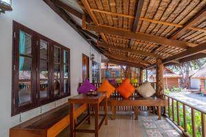 a porch with a wooden table with colorful pillows on it at Lipe Beach Resort in Ko Lipe