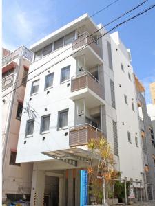 un edificio blanco con balcones en un lateral en Across Omoromachi Naha en Naha