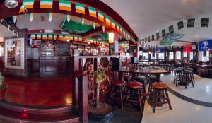un restaurante con un bar con mesas y taburetes en The Lombard Townhouse, en Dublín