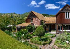 una casa con un jardín delante de ella en Gate Keepers Cottage en Akaroa