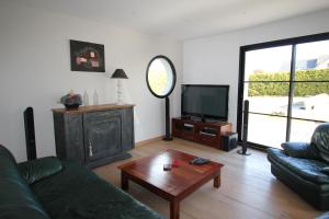 Una sala de estar con un sofá y una mesa de café. en Contemporary Villa of Kerseal, en Gouesnach