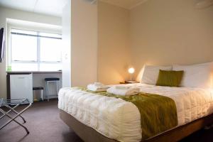 Un dormitorio con una cama con toallas. en City Lodge Accommodation, en Auckland