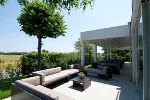 eine Terrasse mit Sofas und einem Baum auf einem Gebäude in der Unterkunft Il Portico in Fano