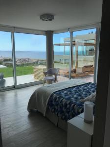 a bedroom with a bed and a view of the ocean at SYRAH Vistas by depptö in Punta del Este