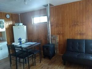 a kitchen with a table and chairs and a stove at Cabaña Centro Pitrufquen in Pitrufquén