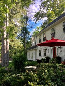 a house with a red umbrella in the yard at Darlington House Bed and Breakfast in Niagara-on-the-Lake