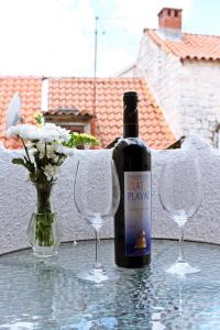 a bottle of wine and two wine glasses on a table at House Ivancic in Trogir