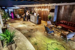 a lobby with people standing at a counter in a room at The Chi Boutique Hotel in Hanoi
