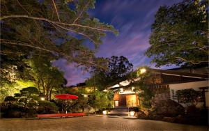 una casa con un patio por la noche con una sombrilla roja en ABBA Resorts Izu - Zagyosoh, en Ito