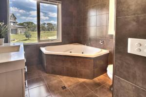 a bath tub in a bathroom with a window at Alpine Edge in Dinner Plain