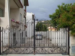 a gate to a house with a car behind it at Affittacamere Peonia in Oliena