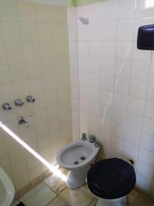 a bathroom with a toilet with a black seat at Hostel Megaró in Santa Teresita +32 photos