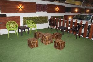 eine Gruppe von Stühlen und Hockern auf dem Gras in der Unterkunft Choice Classic Hotel in Pune