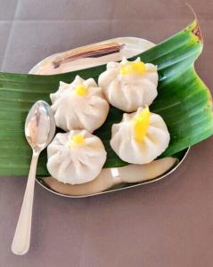 a plate of food with white flowers and a spoon at Oasis Resort in Diveagar