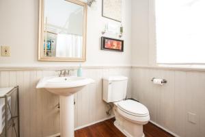 a bathroom with a sink and a toilet and a mirror at Creole Cottage Uptown in New Orleans +22 photos