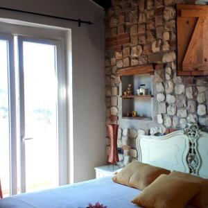 una camera con letto e parete in pietra di Il Debbio a Riccò del Golfo di Spezia